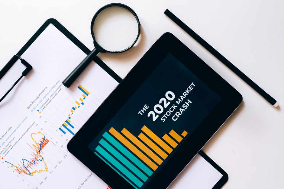 Economia do Turismo — Magnifying glass and tablet analyze 2020 stock market crash data with charts on clipboard.