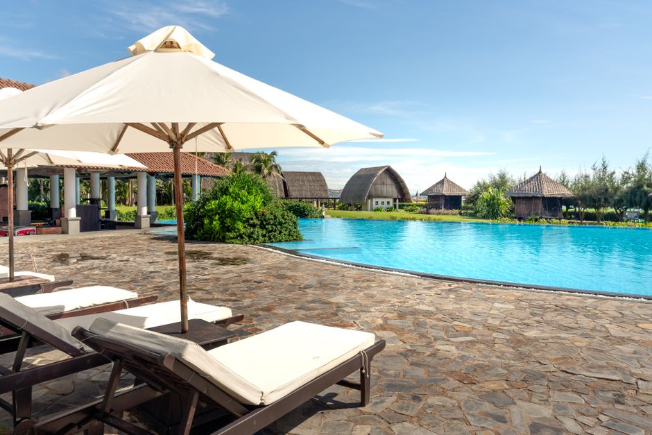 Economia do Turismo — Experience a tropical paradise at this luxurious resort with a stunning pool and relaxation area.